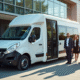 Minibus blanc moderne devant un bureau avec professionnels